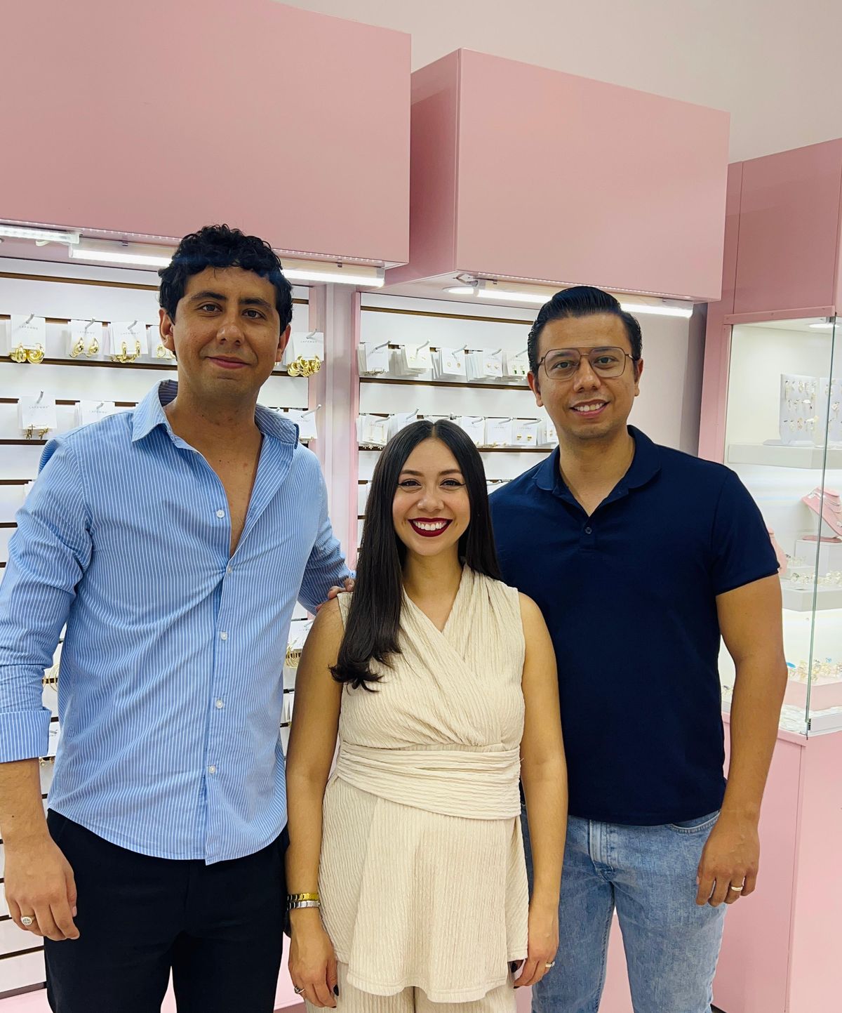 El equipo de La Femme en su tienda, delante de las vitrinas rosas con aretes, anillos y collares